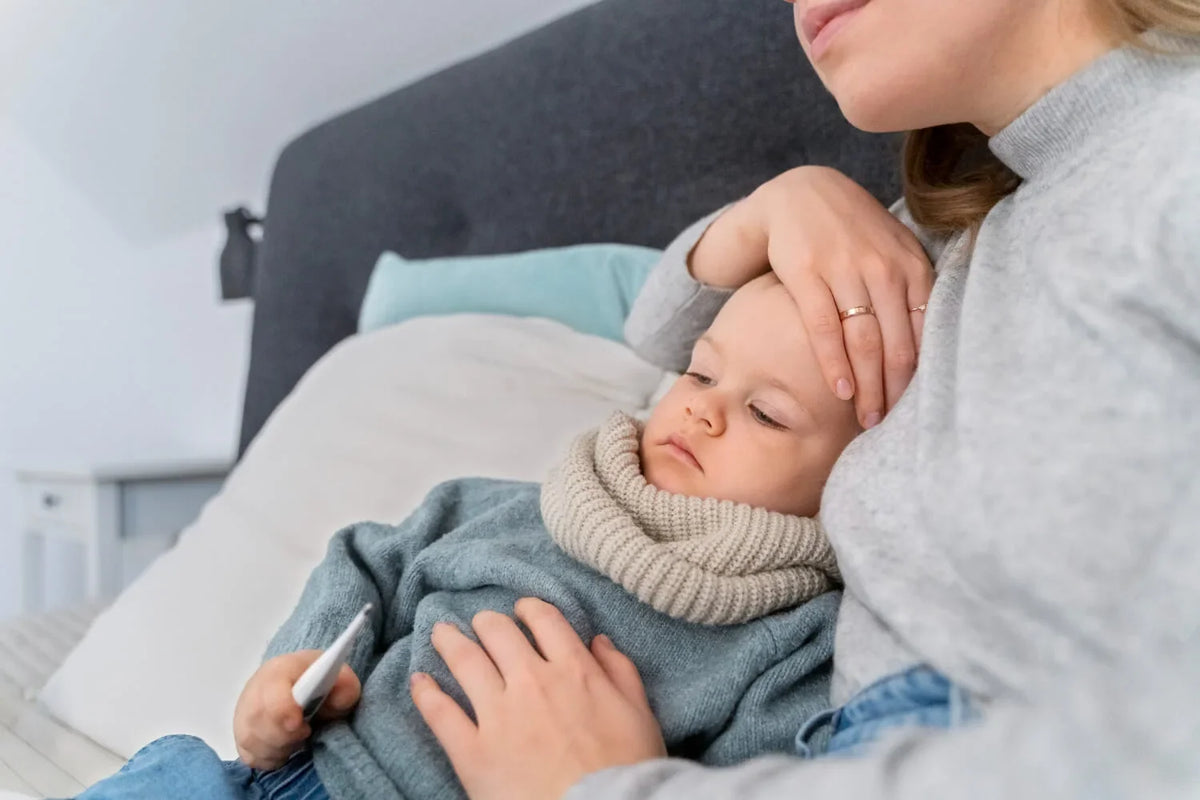 bébé enrhumé dans les bras de sa mère