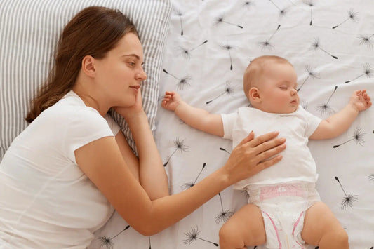 bébé s'endort avec maman à côté de lui