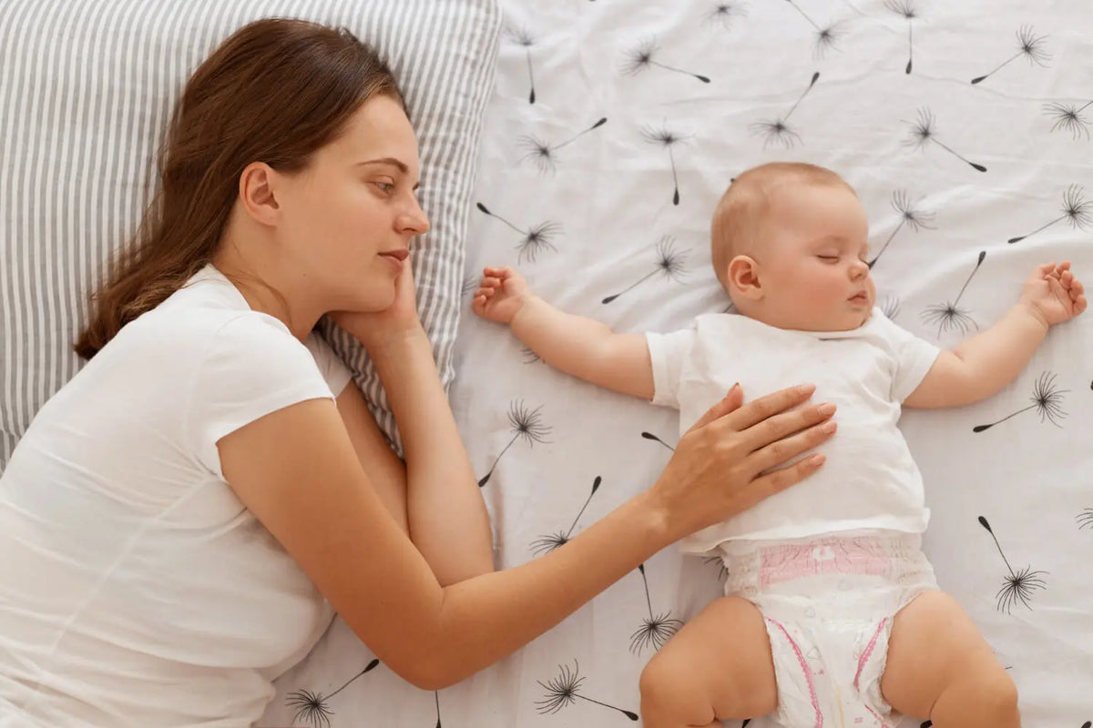 bébé s'endort avec maman à côté de lui